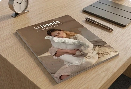 Katalog marki HOMLA „The Art of Cozy Living” na biurku